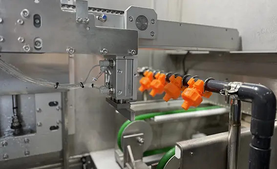 Orange nozzle assembly inside an equipment enclosure
