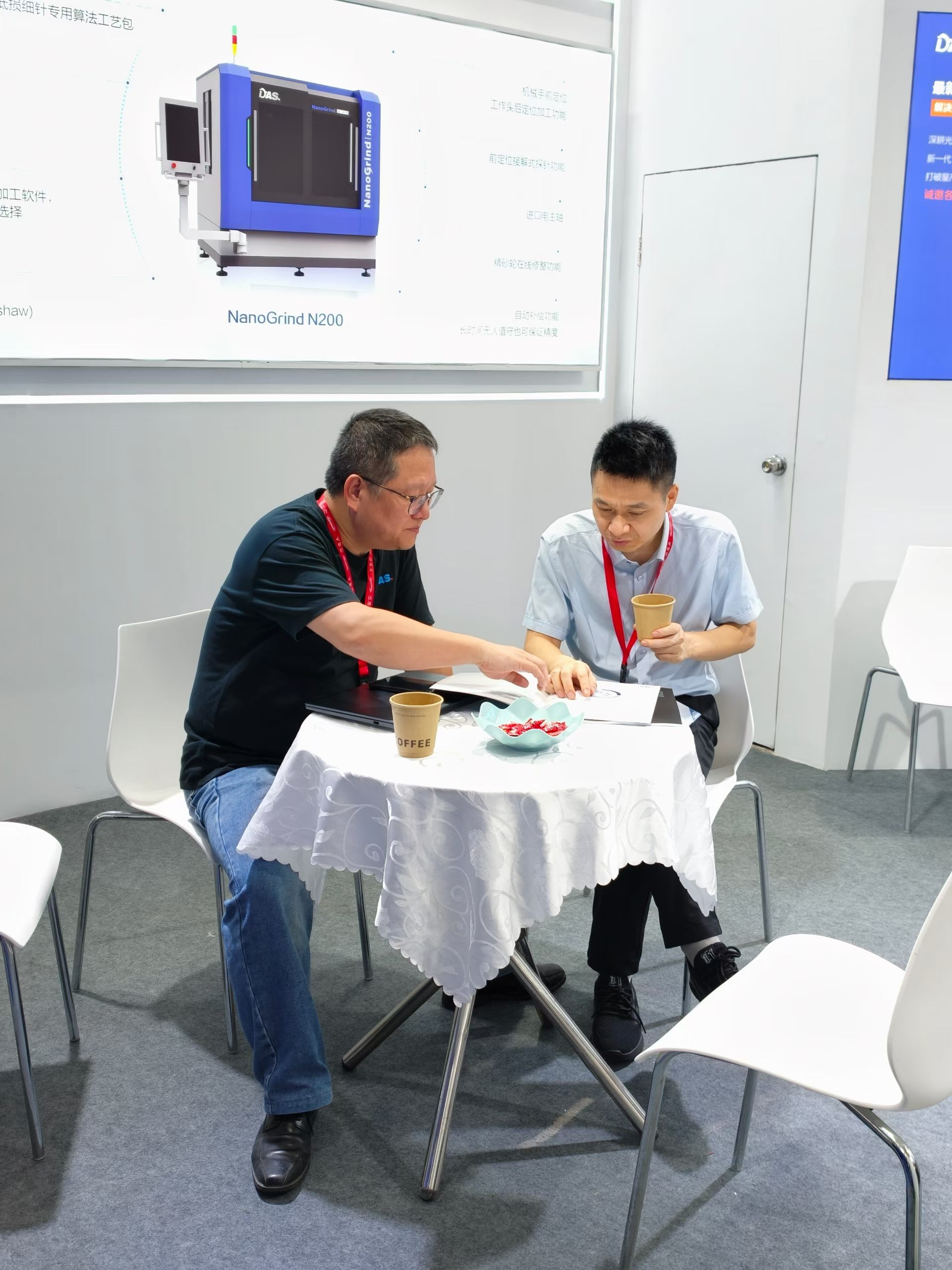 Two people seated at an exhibition table
